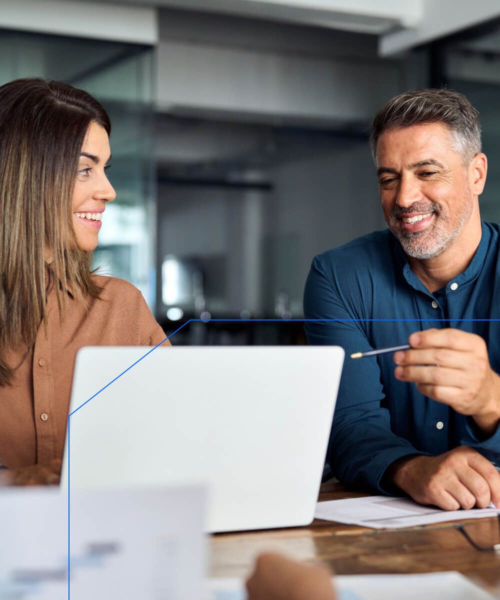 Business professionals discussing strategy using a laptop in a collaborative workspace - Neutrinos
