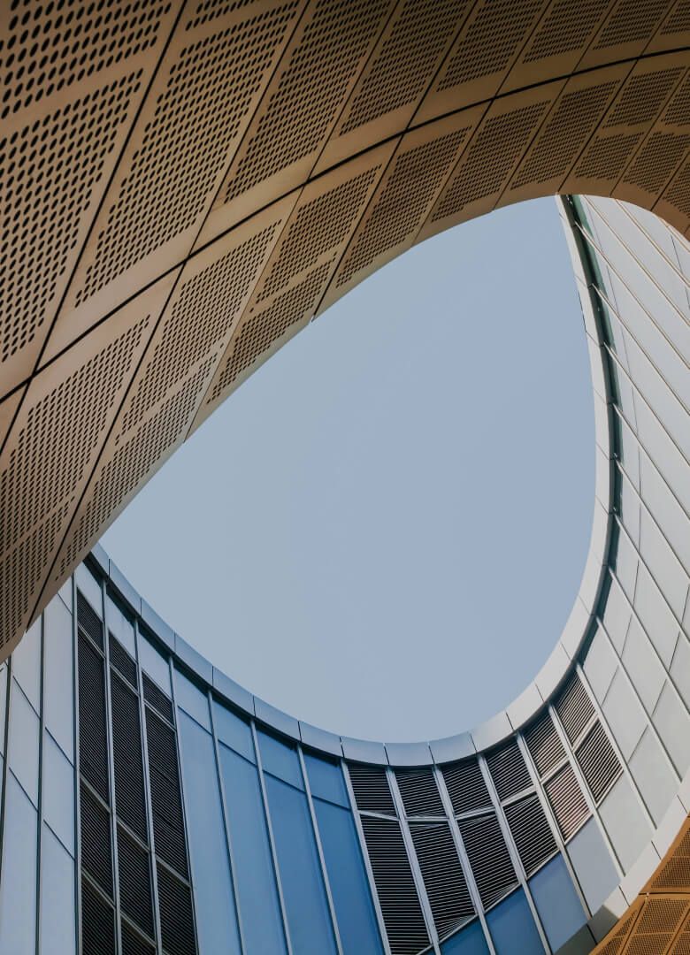 View from inside a modern curved building with glass and perforated metal panels - Neutrinos