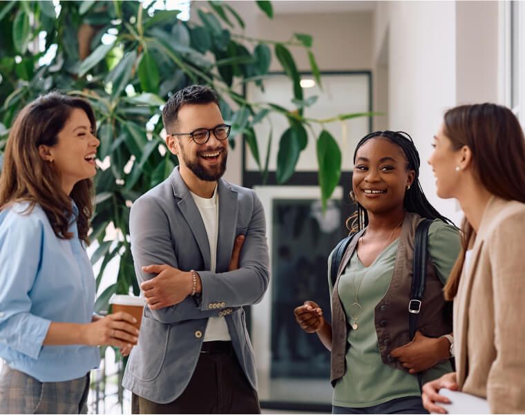 Group of diverse professionals smiling and talking in a modern office space - Neutrinos