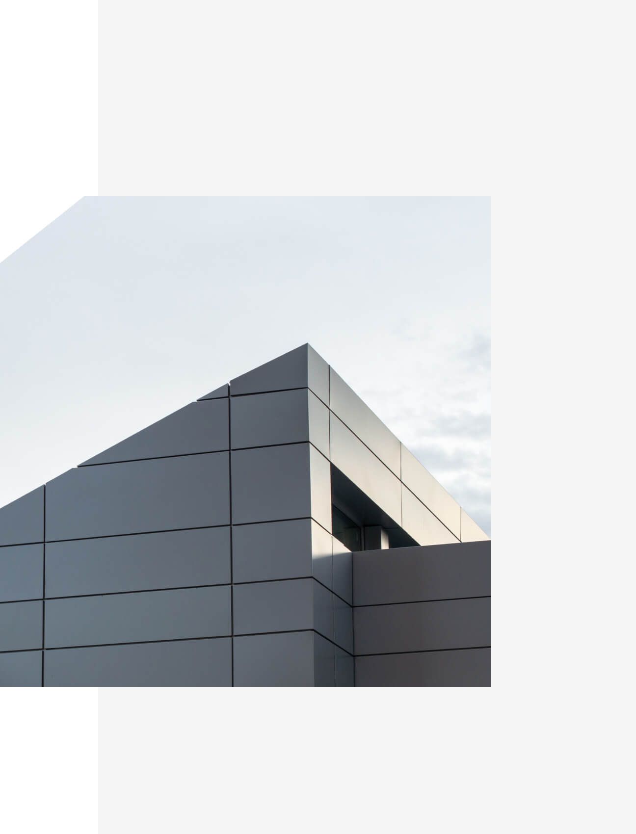 Contemporary building with sharp lines and metal panel facade against a cloudy sky - Neutrinos