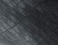 Close-up of dark textured metal or concrete panels with diagonal lines-Neutrinos